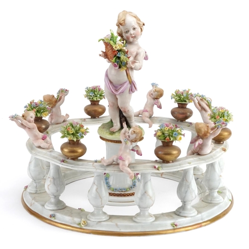 547 - Capodimonte, Italian Naples porcelain centrepiece in the form of Putti standing on a pillar surround... 