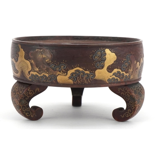 127 - Japanese hardwood three footed stand lacquered and gilded with crashing waves, 10.5cm in diameter