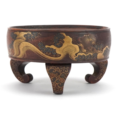 127 - Japanese hardwood three footed stand lacquered and gilded with crashing waves, 10.5cm in diameter