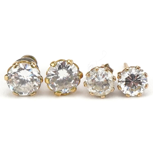 2353 - Two pairs of unmarked gold clear stone stud earrings, the largest 7mm in diameter, total 2.0g