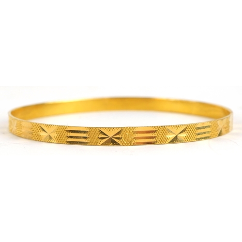 2043 - Unmarked gold engine turned bangle, tests as 18ct gold, 6.5cm in diameter, 13.4g