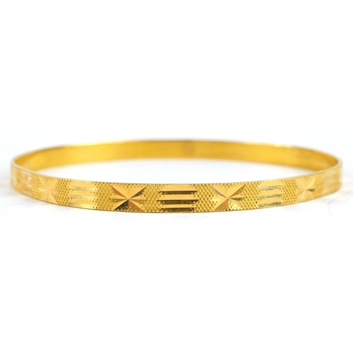 2043 - Unmarked gold engine turned bangle, tests as 18ct gold, 6.5cm in diameter, 13.4g