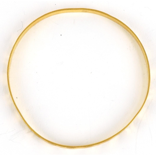 2043 - Unmarked gold engine turned bangle, tests as 18ct gold, 6.5cm in diameter, 13.4g