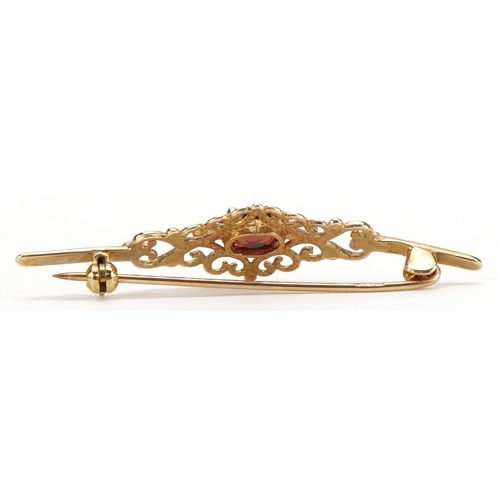 2195 - 9ct gold openwork garnet bar brooch, 4.4cm wide, 2.4g