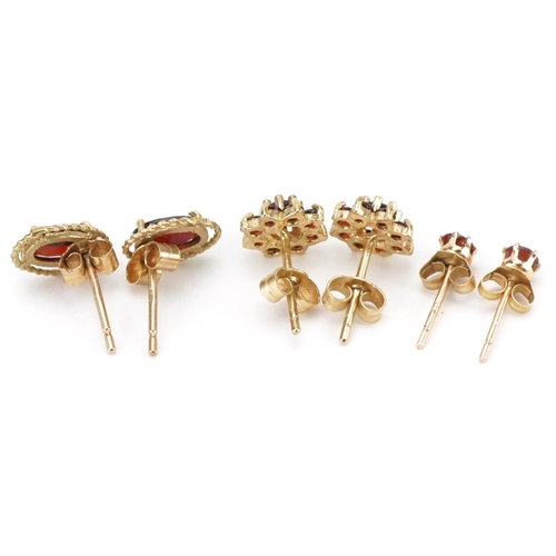 2192 - Three pairs of 9ct gold garnet earrings comprising solitaire studs and flower head clusters, the lar... 