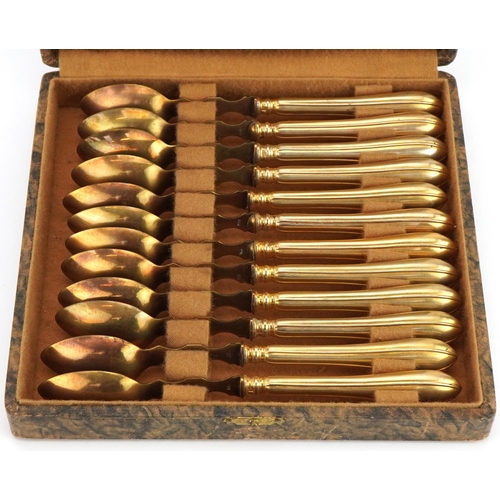 1245 - Set of twelve gilt metal spoons impressed THEO housed in a fitted case, 16.5cm in length