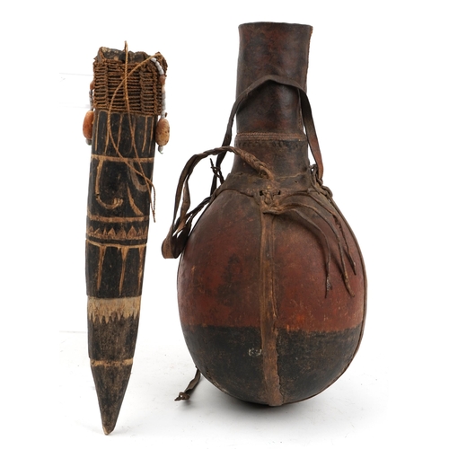 1374 - Tribal interest African leather bound wood gourd and one other, the largest 40cm high