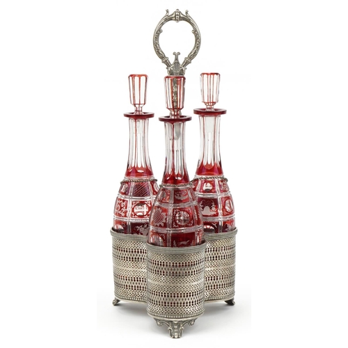 230 - 19th century silver plated three bottle tantalus housing three Bohemian ruby flashed cut glass decan... 