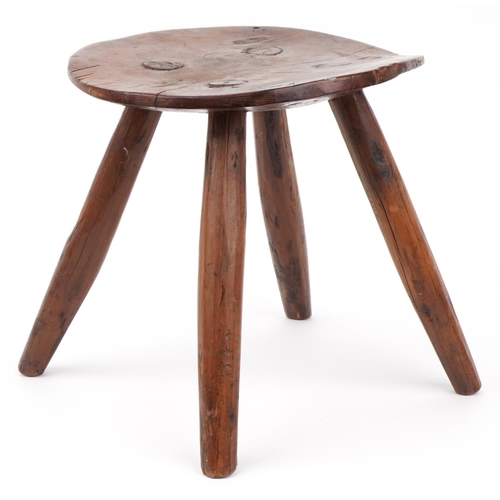 1033 - Farmhouse style yew wood four footed stool, 28cm high x 27.5cm in diameter