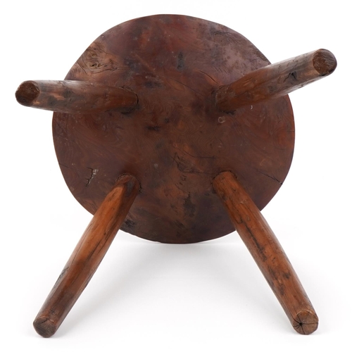 1033 - Farmhouse style yew wood four footed stool, 28cm high x 27.5cm in diameter