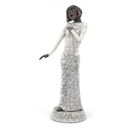 675 - Pottery figurine of a jazz singer having a raku glaze, 41cm high