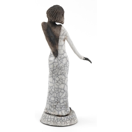 675 - Pottery figurine of a jazz singer having a raku glaze, 41cm high