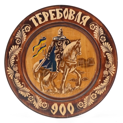 541 - European wooden plate carved with a knight on horseback, 40cm in diameter