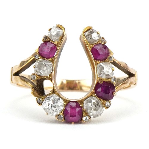 2307 - 19th century unmarked gold diamond and ruby horseshoe ring, tests as 18ct gold, the largest diamond ... 