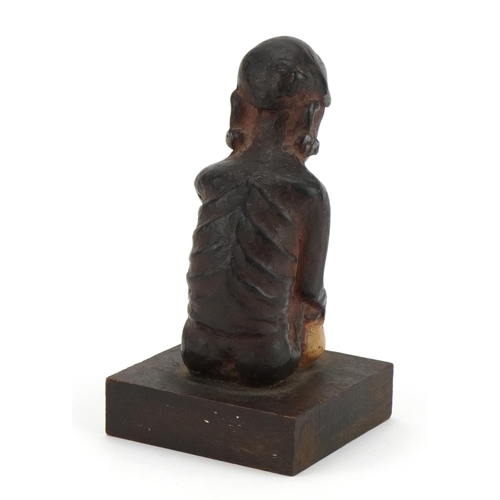 297 - Tribal interest pottery figure of a crouched nude male raised on a wooden square block base, 13cm hi... 