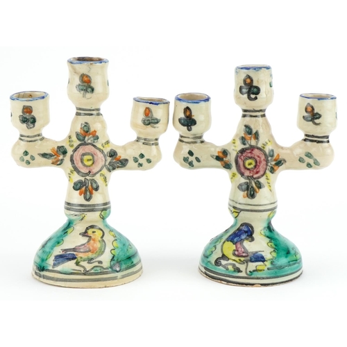 734 - Pair of Turkish pottery three branch candelabras hand painted with birds and flowers, 19cm high