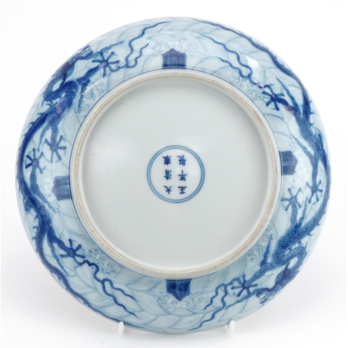 623 - Chinese blue and white porcelain shallow dish finely hand painted with dragons amongst crashing wave... 