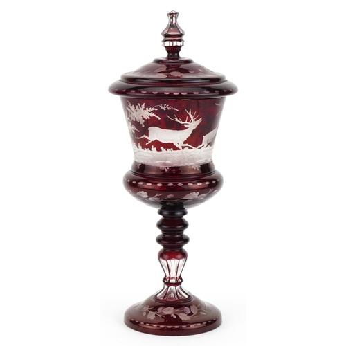 218 - 19th century Bohemian ruby overlaid glass goblet and cover etched with wild animals amongst foliage,... 