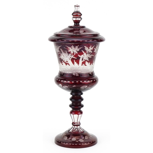 218 - 19th century Bohemian ruby overlaid glass goblet and cover etched with wild animals amongst foliage,... 