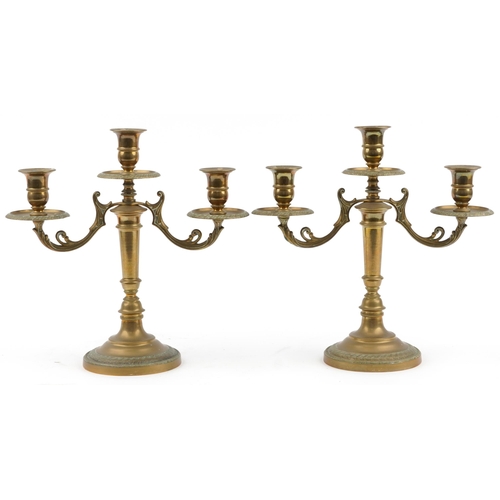 335 - Pair of classical three branch brass candelabras engraved with flowers, each 32cm high