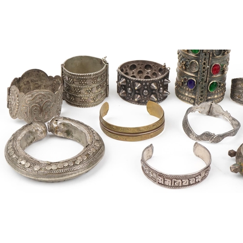 292 - Tribal interest jewellery including white metal bangles and white metal cuffs with coloured stones, ... 