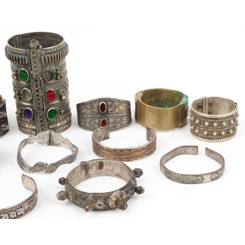 292 - Tribal interest jewellery including white metal bangles and white metal cuffs with coloured stones, ... 