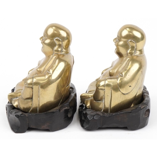 360 - Pair of Chinese brass Buddhas raised on carved hardwood stands, each 10cm wide