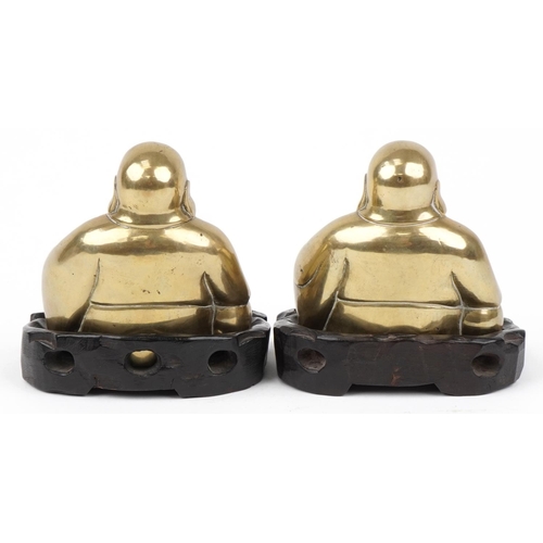 360 - Pair of Chinese brass Buddhas raised on carved hardwood stands, each 10cm wide