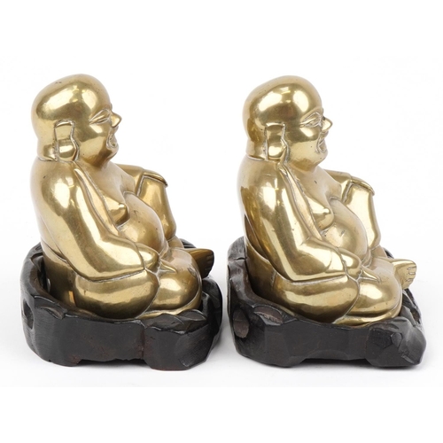 360 - Pair of Chinese brass Buddhas raised on carved hardwood stands, each 10cm wide