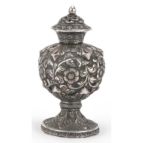 287 - Anglo Indian unmarked silver caster profusely embossed with flowers and foliage, 9cm high, 74.2g