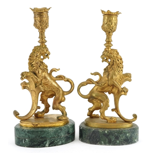 172 - Pair of Italian style gilt metal candlesticks in the form of rampant lions raised ooval green marble... 