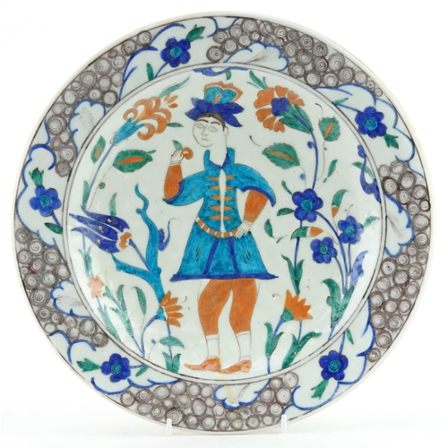 68 - Turkish Iznik plate hand painted with a figure amongst stylised flowers, 32cm in diameter