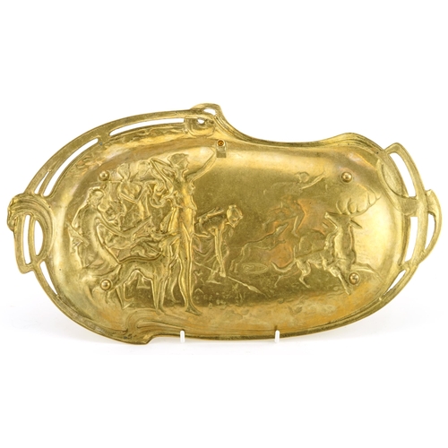 477 - Continental Art Nouveau brass four footed tray decorated in relief with Diana the Huntress, indistin... 