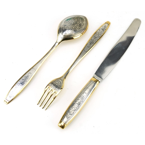 254 - Russian partially gilt silver niello work knife, fork and spoon set housed in a fitted box, the knif... 