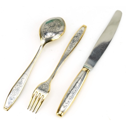 255 - Russian partially gilt silver niello work knife, fork and spoon set housed in a fitted box, the knif... 