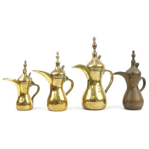 74 - Four Omani brass dallah coffee pots, the largest 38cm high