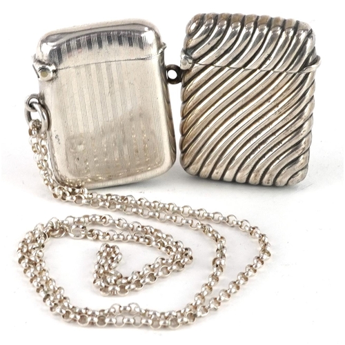 256 - Two Edwardian and later silver vestas, one with embossed decoration and a silver Belcher link chain,... 