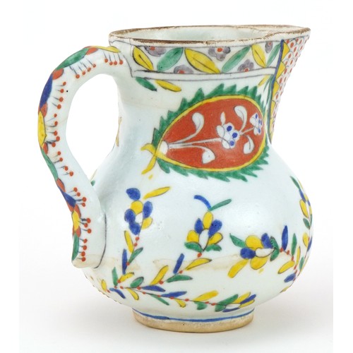 29 - Turkish Ottoman Kutahya pottery handled jug hand painted with stylised flowers, 12.5cm high