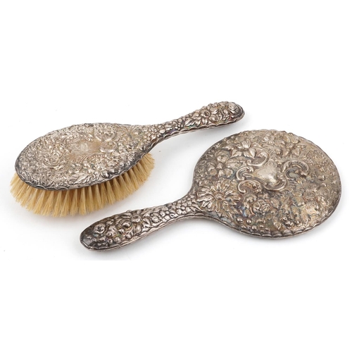 70 - Silver backed hand mirror and clothes brush profusely embossed with flowers and foliage, S M maker's... 