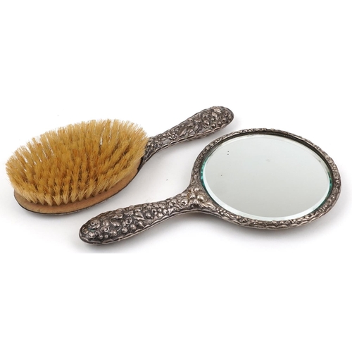 70 - Silver backed hand mirror and clothes brush profusely embossed with flowers and foliage, S M maker's... 