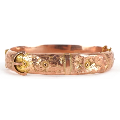 63 - Edwardian 9ct rose gold buckle design hinged bangle engraved with flowers and foliage, 6.5cm wide, 1... 