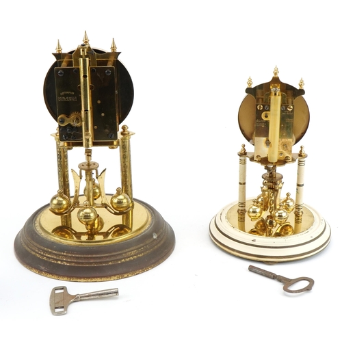 123 - Two brass anniversary clocks housed under glass domes including a Kundo example, the largest 30cm hi... 