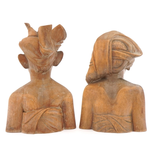 128 - Two Balinese carved wood busts, the largest 24cm high