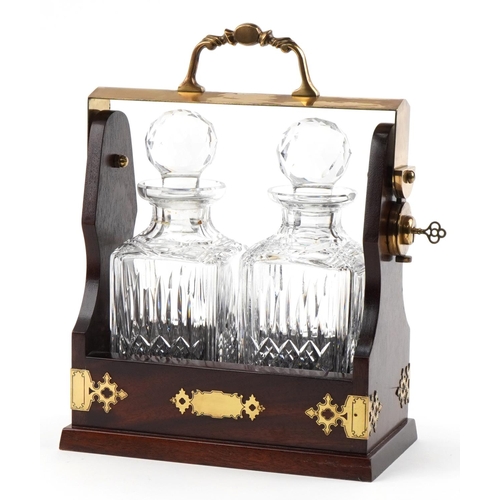 355 - Mahogany and brass two bottle tantalus with key housing a pair of Stuart Crystal decanters with stop... 