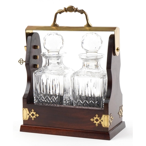 355 - Mahogany and brass two bottle tantalus with key housing a pair of Stuart Crystal decanters with stop... 