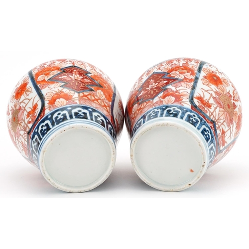 481 - Pair of Japanese Imari porcelain vases and covers hand painted with flowers, each 28cm high