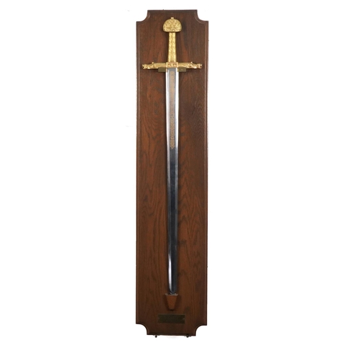 2507 - Decorative Sword of Charlemagne with gilt handle mounted on an oak back, overall 112cm in length