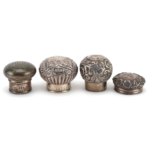 128 - Four silver scent bottle tops including floral examples, various hallmarks including London, the lar... 