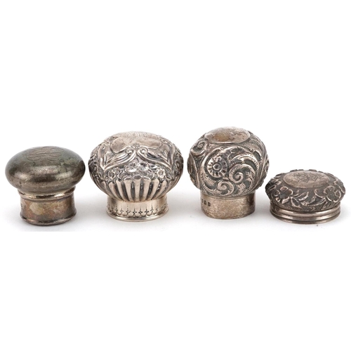 128 - Four silver scent bottle tops including floral examples, various hallmarks including London, the lar... 