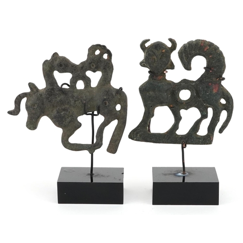 388 - Two Persian Luristan patinated mythical animal bronzes including a handle, each raised on stands, th... 